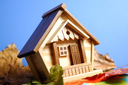 Little wooden house model under blue skyの写真素材