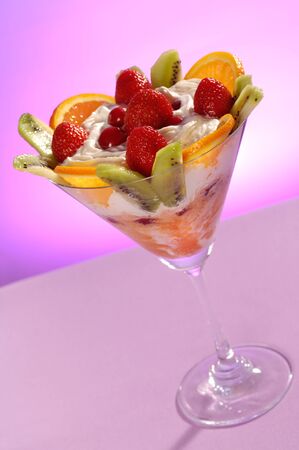Martini glass filled with colorful fruit ice cream isolated on pink backgroundの写真素材