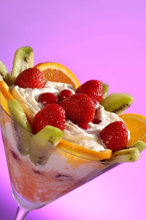 Martini glass filled with colorful fruit ice cream isolated on pink backgroundの写真素材