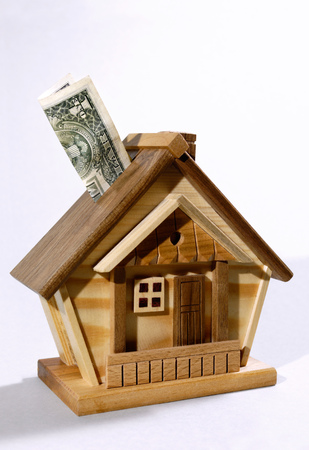 Dollar bill being deposited into a house money box. Investment, real estate, mortgage conceptの写真素材