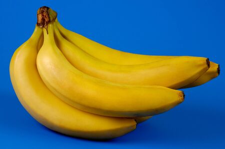Bunch of bananas isolated silhouette on blue backgroundの写真素材