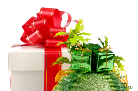 Gift box with a red bow and a Christmas bauble isolated on white backgroundの写真素材