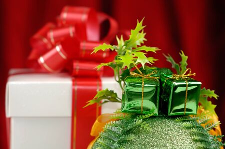 Gift box with a red bow and a Christmas baubleの写真素材