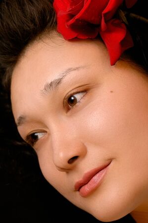 Beautiful young asian girl face with a red roseの写真素材
