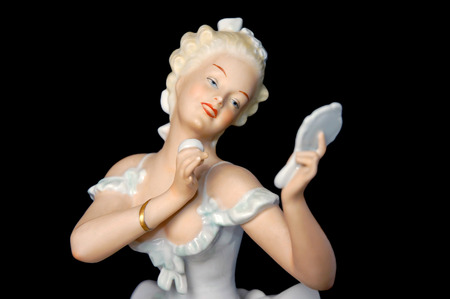 Ceramic Figure of a Pretty Young Lady Looking at a Mirrorの写真素材