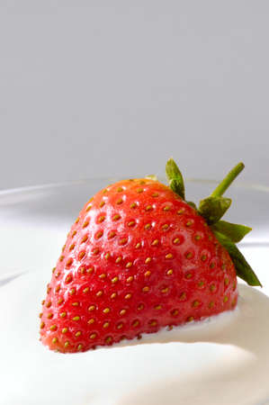 Closeup of an appetizing strawberry in cream on gray backgroundの写真素材