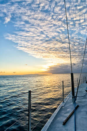 View of a beautiful orange sunset from the deck of a sailing boat in the Australian sea near the...