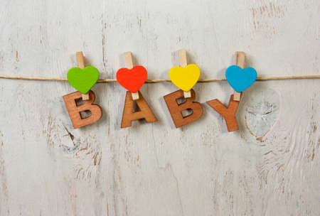 the word baby and heart on clothespins on a white background old