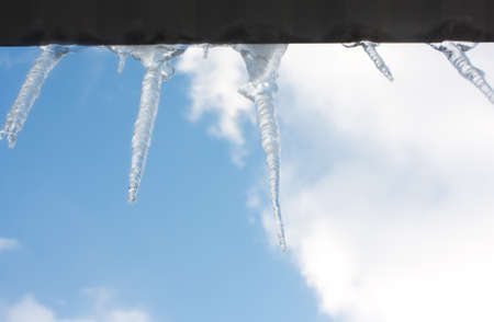 Icicles hanging from the roof of the ice against the sky