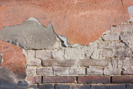 Old destroyed plaster at a brick wall. Grunge cement, with a shabby paint background.