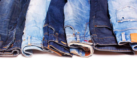 Many different blue jeans in a row on a white backgroundの写真素材
