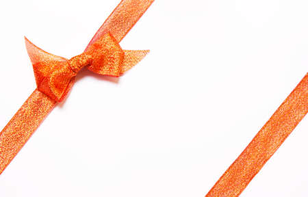 Red golden, orange  ribbons with bow with tails  on white background. The concept of gift, holidayの写真素材