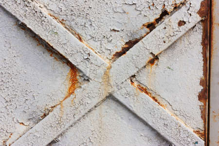 Cross on metal doors, a background of gray, cracked paint, iron texture and rustの写真素材