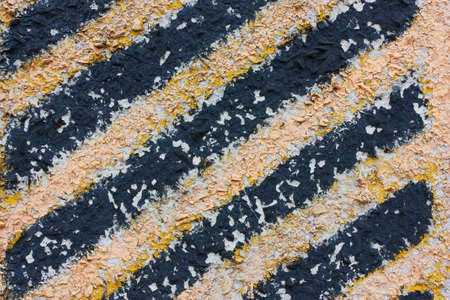 Yellow black strips of old, cracked paint. Road sign carefully, danger.の写真素材