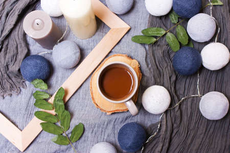 Cup of coffee, cocoa and candles, green branches, leaves on a stylish background, top view, flatの写真素材