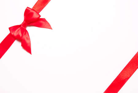 Red ribbons with bow with tails  on white background. The concept of gift, holidayの写真素材