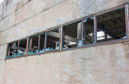 Broken windows in an old abandoned factoryの写真素材