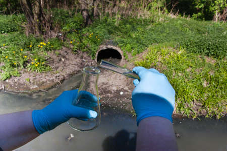 Check the water sample for infections. Hand in a glove with a bulb and a test tube against the...