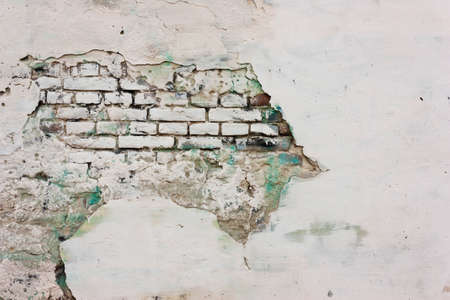 Wall of plaster with white and green paint, and brick.の写真素材