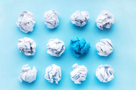 blue wrinkled ball of paper among the whites. Concept of ideas, differences, leadership. View from above, flatの写真素材