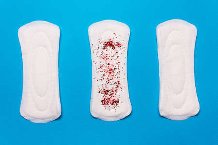 three menstrual pads on a blue background. Concept of critical days, menstrual cycle, menstruationの写真素材