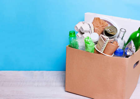 In a cardboard box plastic, glass bottles, cans, paper. The concept of separate sorting of garbage,...