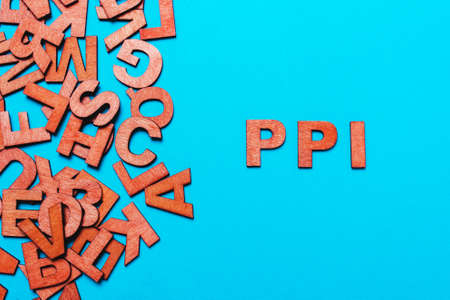 abbreviation PPI - Payment Protection Insurance.Wooden letters on blue backgroundの写真素材