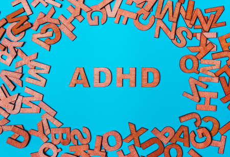 Word ADHD from wooden letters on a blue background. attention deficit hyperactivity disorder handwrittenの写真素材