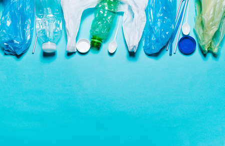 Plastic bags, bottles, tubes, spoons, caps on a blue background. The concept of using...