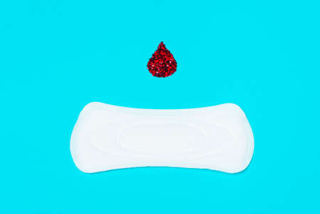 menstrual pads with a drop of blood on a blue background. Concept of critical days,  cycle, menstruationの写真素材