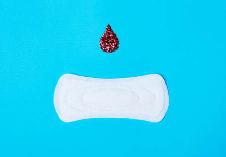 menstrual pads with a drop of blood on a blue background. Concept of critical days,  cycle, menstruationの写真素材