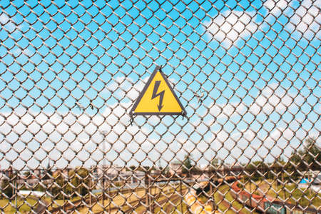 Yellow sign of danger on the fence, the gridの写真素材