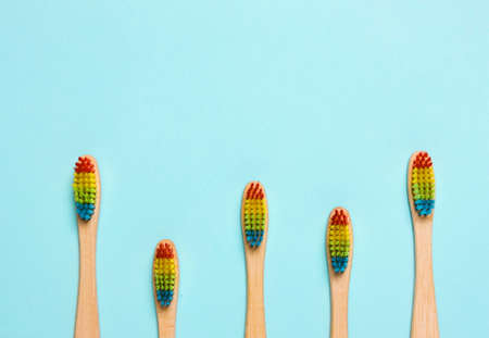 Eco bamboo toothbrush, organic on a blue background of colored bristles.  view i flat, from above. Concept of protection of nature, the environment.の写真素材