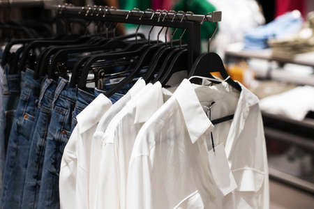 Women's clothes, fashionable, stylish on hangers in stores. Shopping Concept, Sales.Jeans and White Shirtsの写真素材