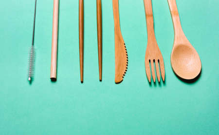 Natural, ecological, Organic wooden fork, spoon, cutlery on a green background. Concept zero waste, environmental pollution.の写真素材