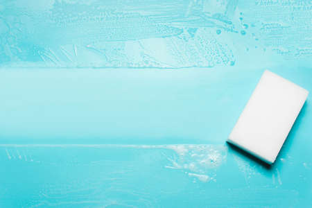 White washcloth and foam detergent on blue background. The concept of cleanliness, cleaning