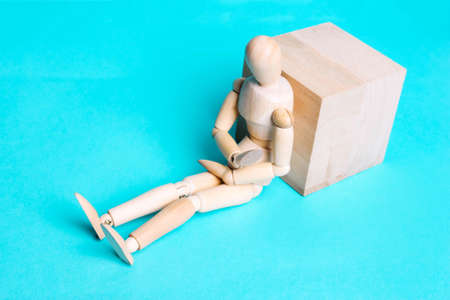 Wooden human figure on a blue background. The concept of pain in the abdomen, stomach,...