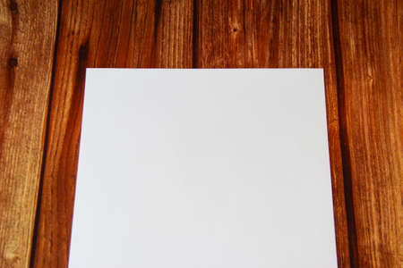 White blank sheet of paper on wooden background with a copyspace