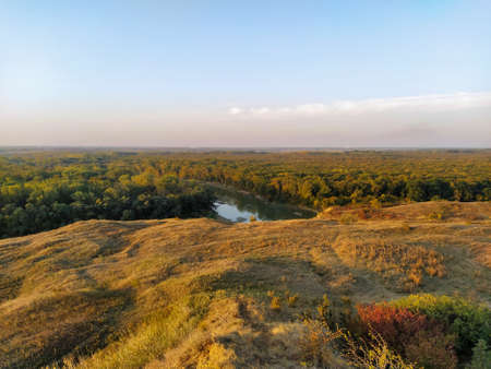 Sunset valley wirh hills and trees and the river below