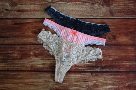Three lace sexy panties on the wooden background with a copyspaceの写真素材