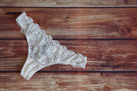 White lace sexy panties on the wooden background with copy space