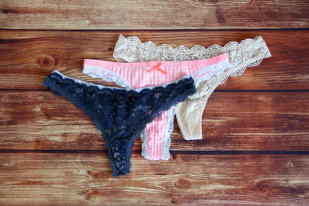 Three lace sexy panties on the wooden background with a copyspaceの写真素材