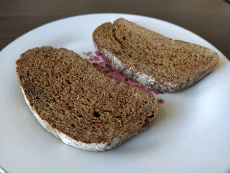Two pieces of black bread on a plateの写真素材