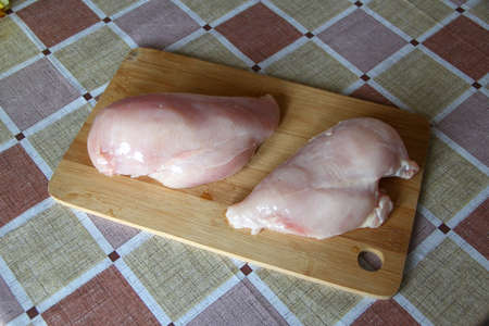 Raw chicken breast on the wooden cutting boardの写真素材