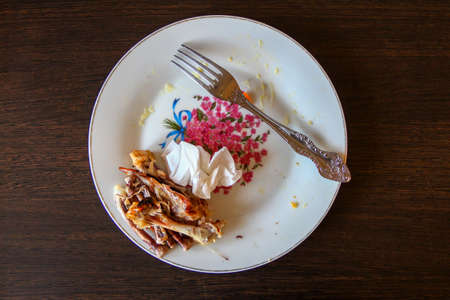 Dirty plate with chicken bones after eating, top viewの写真素材