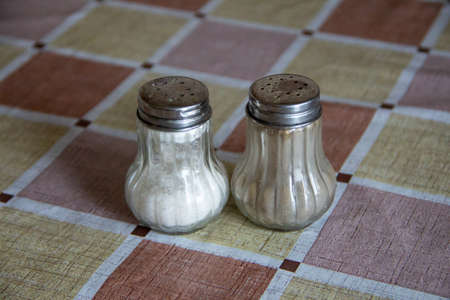 Solt and paper shakers on the table, isolatedの写真素材