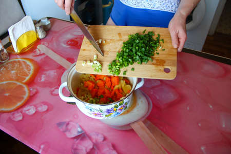 Woman cuts green onions on the cutting boardの写真素材