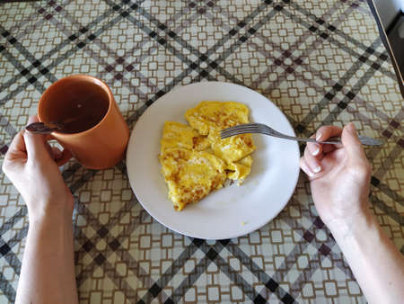Woman eats omelette first person photo