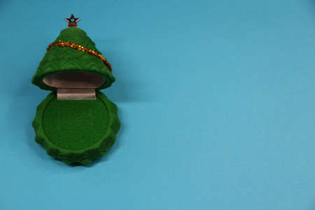 Open gift box in the form of a Christmas tree on the blue background