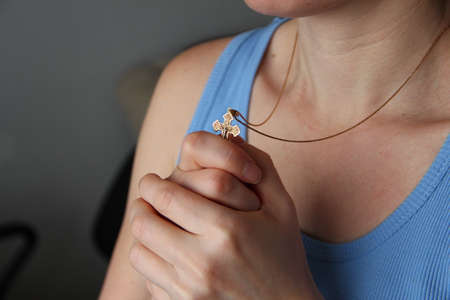 Golden Christian cross in the female hands, closeの写真素材